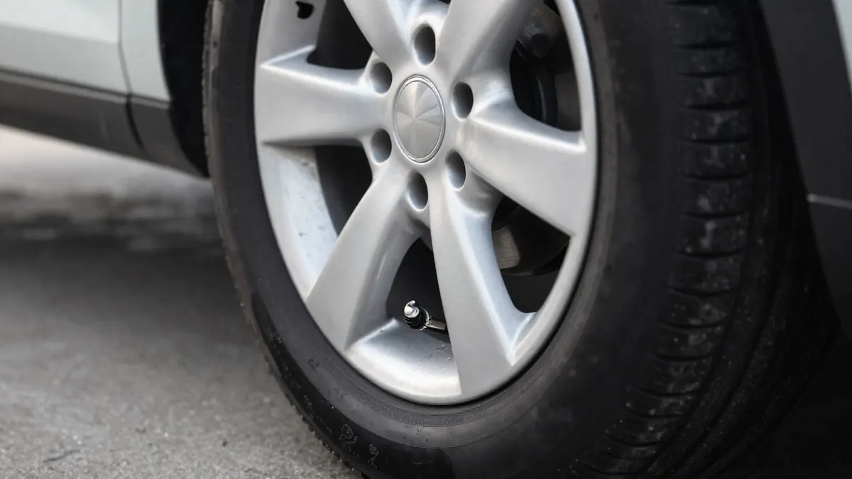 Chrome tire pressure alert cap on the valve stem of an alloy car wheel
